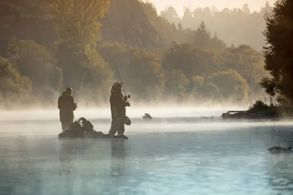 Uomini che pescano nel fiume con la canna della mosca durante la mattina estiva . — Foto Stock