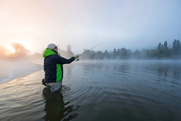 Mens vissen in de rivier met vliegen staaf tijdens Zomerochtend. — Stockfoto