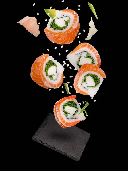 Pedaços de delicioso sushi japonês congelado no ar. — Fotografia de Stock