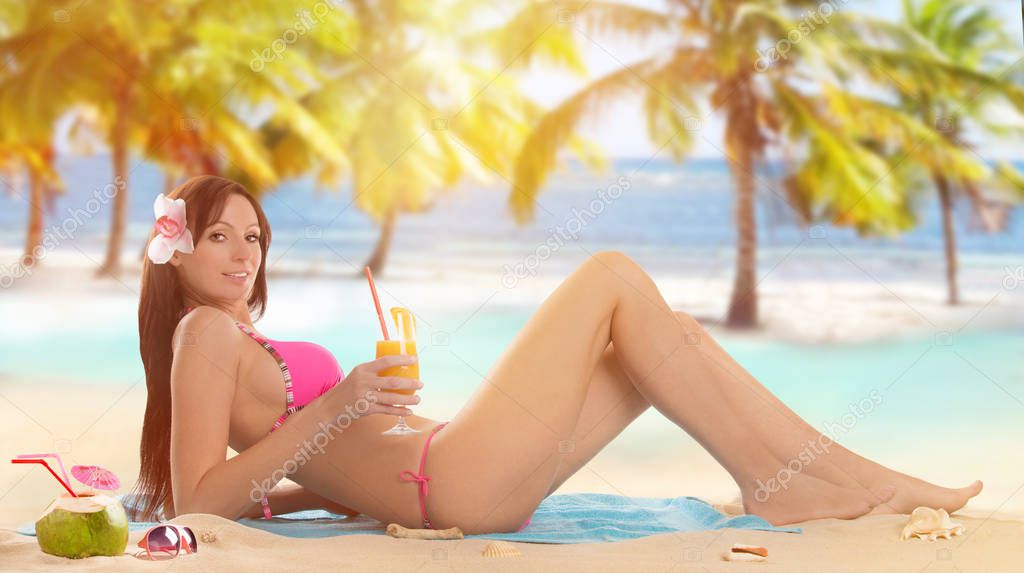 Woman holding a fruit cocktail on a tropical beach