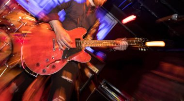 Gitarist sahnede elektro gitar çalıyor.