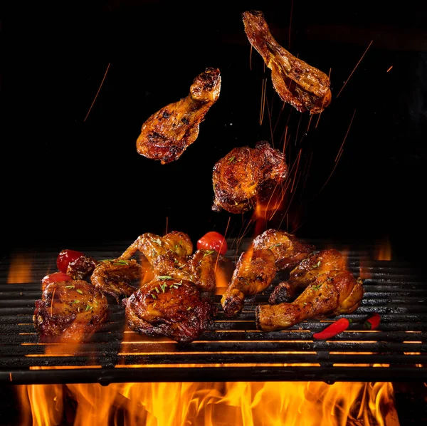 Pernas de frango e asas na grelha com chamas — Fotografia de Stock