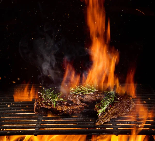Steaks de boeuf sur le gril avec des flammes — Photo
