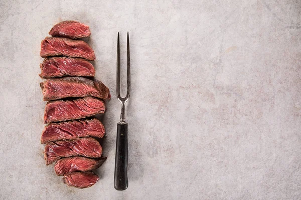 Grilled beef steak on black stone table. Top view. — Stock Photo, Image