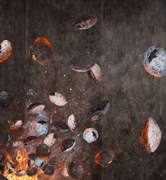 Vattenkokare grill med varma briketter och kostar järn rutnät flyger i luften. — Stockfoto
