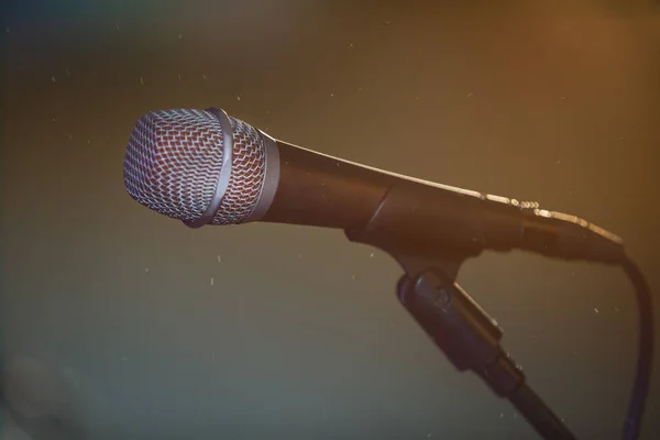 Metal microphone in holder on dark background — Stock fotografie