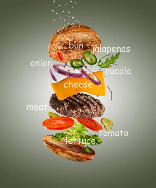 Sabrosa hamburguesa con ingredientes voladores sobre fondo pastel de color — Foto de Stock