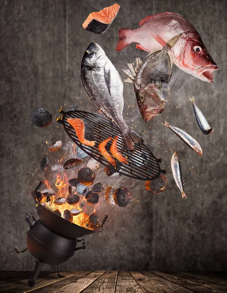 Czajnik Grill z płomieniem ognia, Żeliwny ruszt i smaczne ryby morskie pływające w powietrzu. — Zdjęcie stockowe
