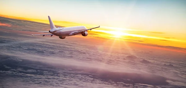 Avión comercial jetliner volando por encima de nubes dramáticas. —  Fotos de Stock