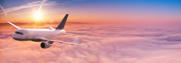 Commercial airplane jetliner flying above dramatic clouds. — Stock Photo, Image