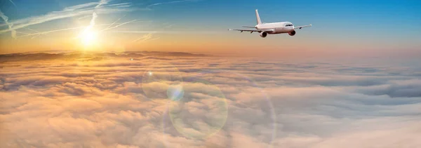 Avião comercial jetliner voando acima de nuvens dramáticas. — Fotografia de Stock