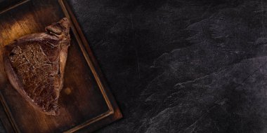 Siyah taş masada ızgara biftek. Üstte görüntü.