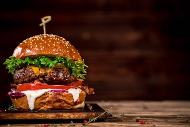 Tasty burger on wooden table. clipart