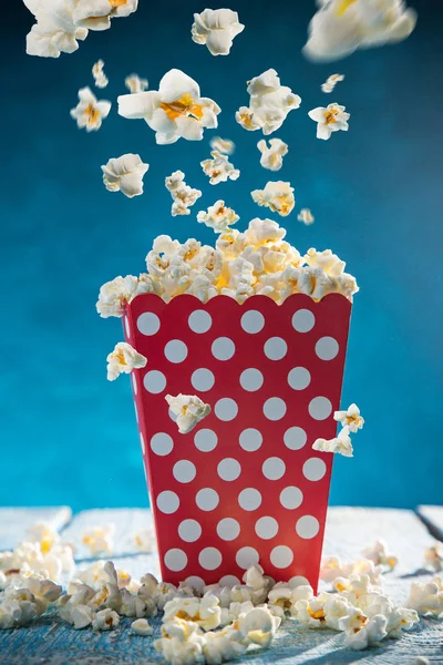 Doos van popcorn op blauwe achtergrond. — Stockfoto