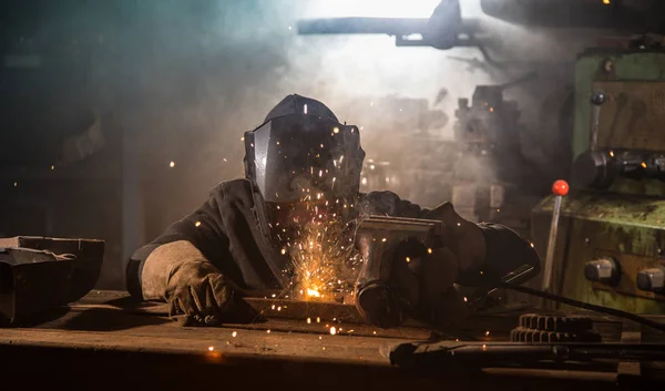 Soldador é soldar parte de metal na fábrica — Fotografia de Stock