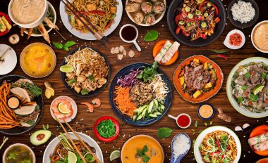 Köy taşından arka planda çeşitli malzemeler içeren Asya yemekleri, üst görünüm.