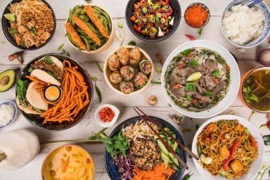 Köy taşından arka planda çeşitli malzemeler içeren Asya yemekleri, üst görünüm.