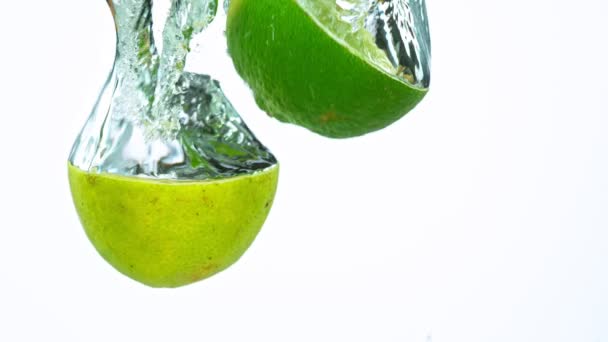 Super Slow Motion Shot of Fresh Limes com Splashing Water — Vídeo de Stock