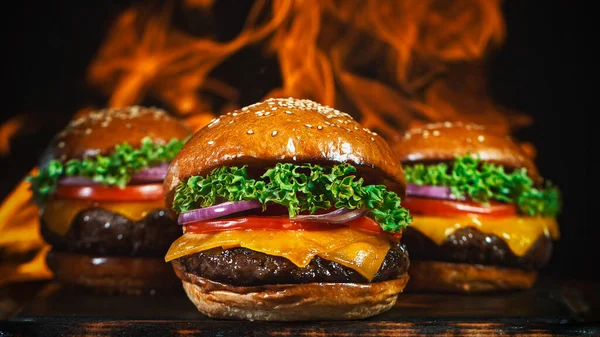 Gustosi cheeseburger, distesi su tagliere vintage in legno. — Foto Stock