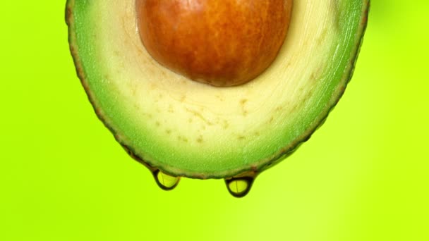 Aguacate fresco cortado con chorro de aceite. Concepto de fruta saludable también útil en cosméticos. — Vídeos de Stock