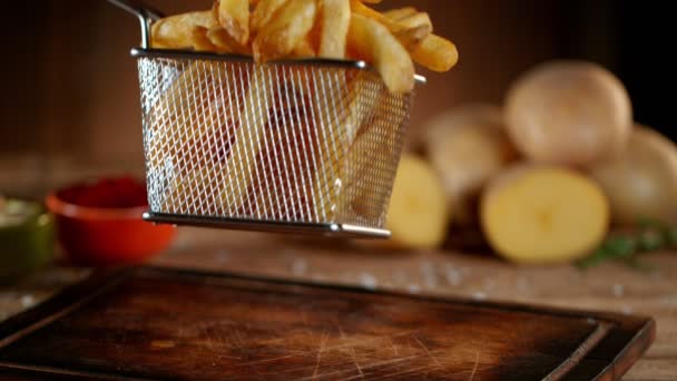 Tiro super lento do movimento de cair fritas francesas frescas na tabela de madeira — Vídeo de Stock