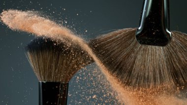 Makyaj fırçaları koyu arkaplanda birbirine dokunur