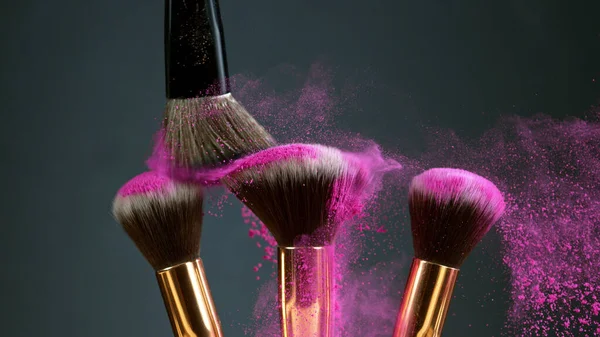 Makeup brushes touch each other on dark background — Stock Photo, Image