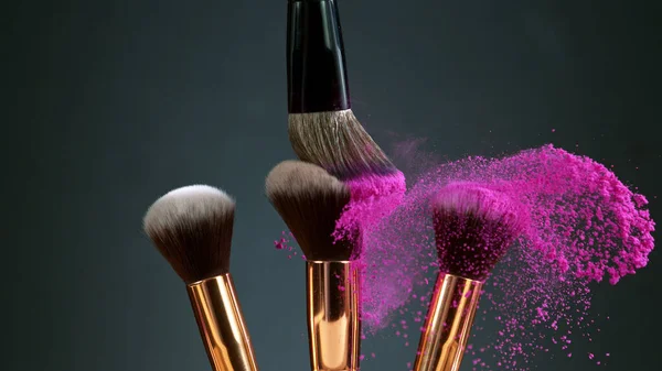 Makeup brushes touch each other on dark background — Stock Photo, Image