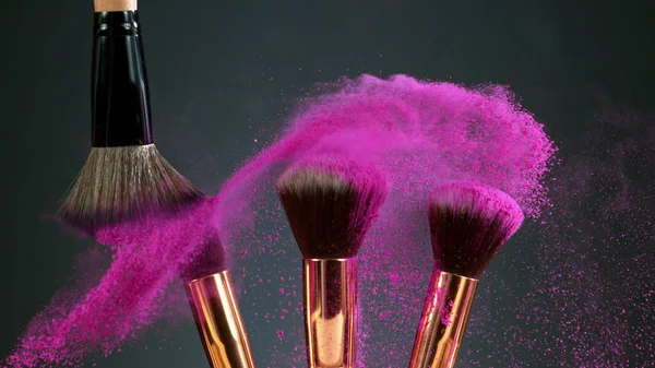 Makeup brushes touch each other on dark background — Stock Photo, Image