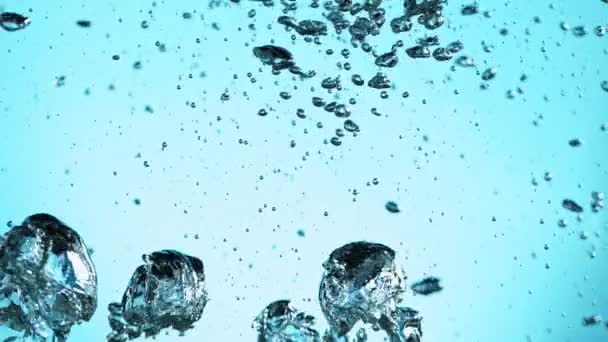 Macro shot di varie bolle d'aria in acqua in movimento lento su fondo azzurro — Video Stock