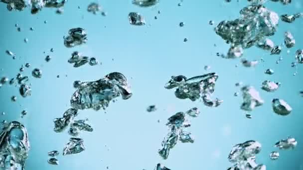 Macro tiro de várias bolhas de ar na água subindo em câmera lenta no fundo azul claro — Vídeo de Stock
