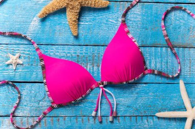 Kırsal ahşap masada güzel bikini ve aksesuarlar..