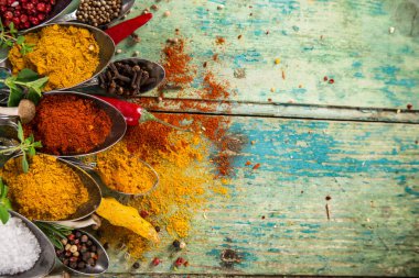 Ahşap masada çeşitli renkli baharatlar var.