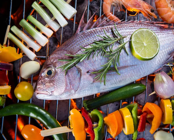 Poissons de mer grillés aux légumes, brochettes et crevettes sur un barbecue. — Photo