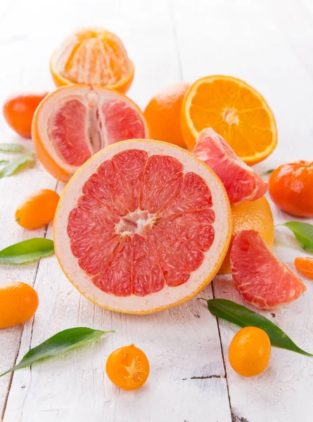 Citrusfrukter på vitt träbord. — Stockfoto