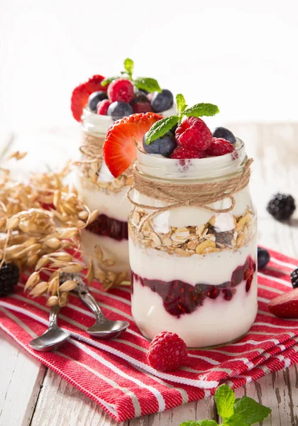 Iogurtes saborosos com muesli, bagas frescas e geléia . — Fotografia de Stock