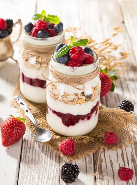 Iogurtes saborosos com muesli, bagas frescas e geléia . — Fotografia de Stock