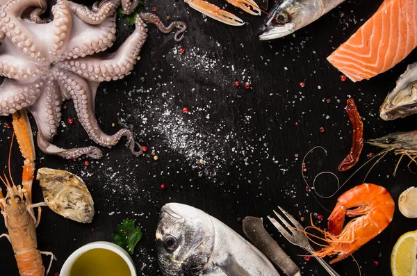 Friss, ízletes tengeri ételek fekete kőasztalra felszolgálva. — Stock Fotó