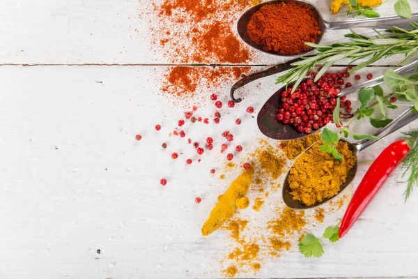 Diverse kleurrijke specerijen op houten tafel — Stockfoto