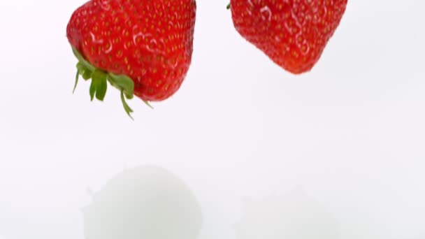 Super cámara lenta de fresas cayendo en crema — Vídeo de stock