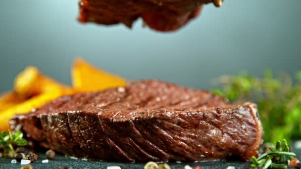 Detailní záběr padajícího chutného hovězího steaku, zpomalený film. — Stock video