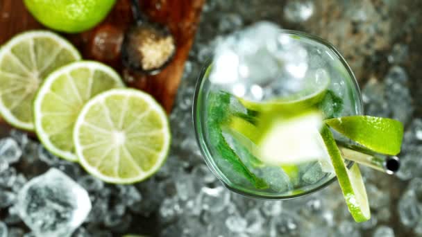 Erfrischender Mojito-Cocktail im Glas auf schwarzem Steintisch, Makro-Zeitlupenaufnahme. — Stockvideo