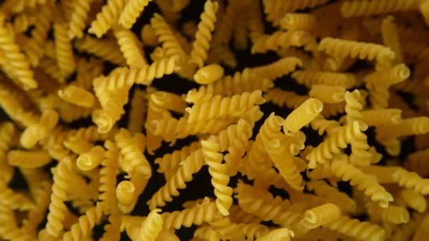 Super slow motion of flying uncooked italian pasta on black background. — Stock Video