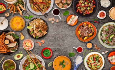 Köy taşından arka planda çeşitli malzemeler içeren Asya yemekleri, üst görünüm.