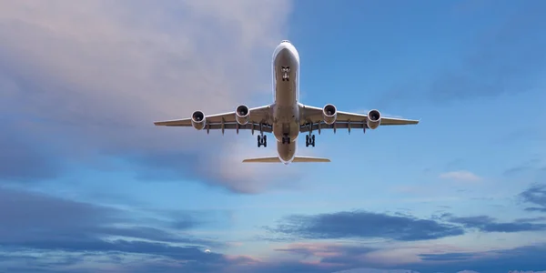 Huge two-storey passengers commercial airplane flying above dramatic clouds, sunset. — Stock Photo, Image