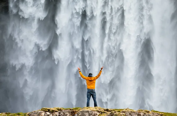 Człowiek podziwia piękno kultowego wodospadu Skogafoss na Islandii — Zdjęcie stockowe