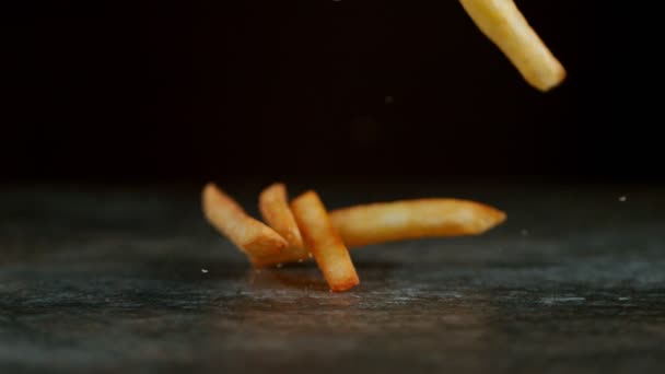 Tiros de movimento super lento de batatas fritas frescas caindo na mesa de pedra — Vídeo de Stock