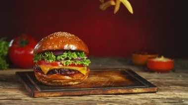 Patates kızartması çizburgerin yanına düşer ve eski ahşap kesme tahtasının üzerine yatar. Süper Yavaş Çekim