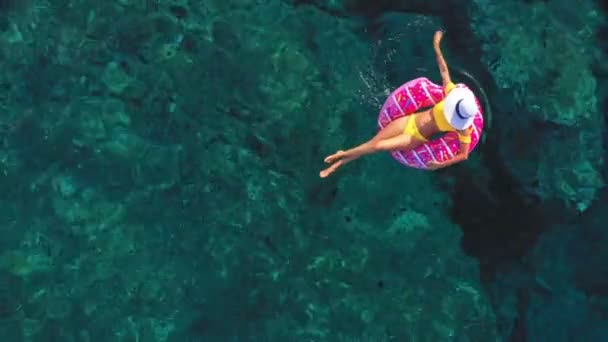 Entspannte junge Frau im Badeanzug im Wasser auf einem aufblasbaren Donut-Ring. — Stockvideo