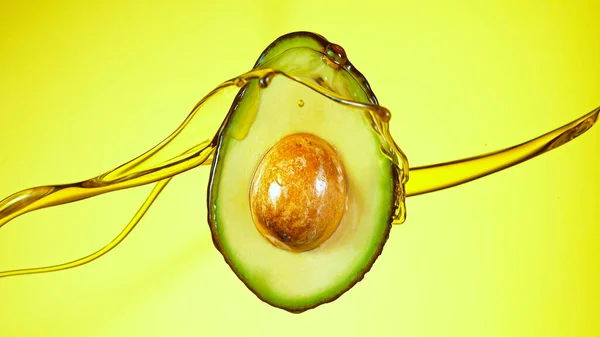 Vers gesneden avocado met oliestroom. — Stockfoto